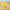 Yellow hamster-shaped litter scoop with hook, hanging on clear pet enclosure, desert background.