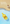 Yellow hamster sand shovel with smooth surface in water, hamster on sand background