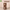 Small hamster peeking out of a wooden tree hole hideout with circular openings, pet accessory